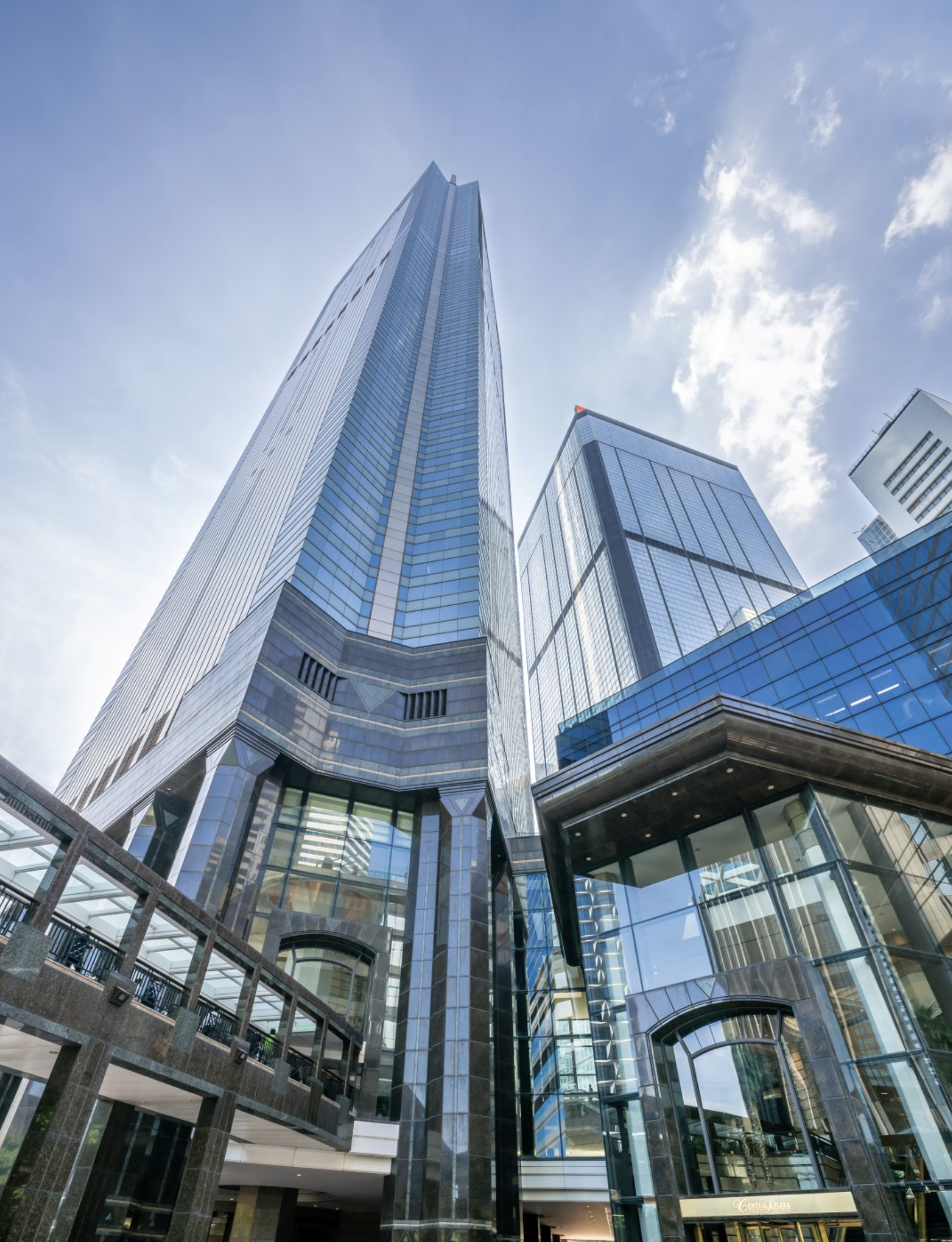 a tall glass building with a walkway